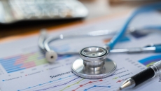 Financial report on a desk with a stethoscope on top