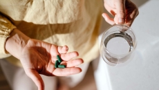 Person holding green pills in their hand