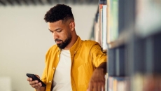 Person standing up and looking at a phone