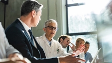 Healthcare providers and business people sitting a room together