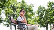 Blind person sitting on a bench in a park