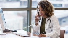 Person sitting at a desk and talking on a phone