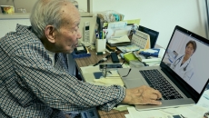 Senior adult consulting with healthcare professional via laptop computer