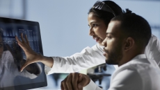 Healthcare professionals reviewing data on a PC