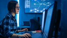 An IT person is working on codes in a desktop computer