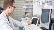 Clinician looking at data on a smart pad  tablet and computer screen