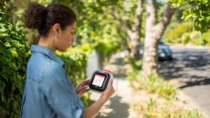 A woman holding the Avive device that is displaying a map