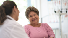 A medical professional talking to a laughing patient