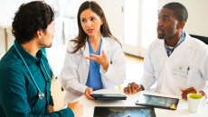 Doctors talking together with digital tablets and X-rays.
