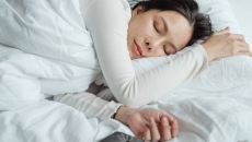 A person sleeping in bed with a smartphone on the side
