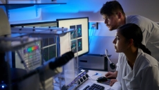 Researchers looking at data on a computer