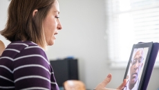 Person sitting at a desk while talking to a healthcare provider on their computer