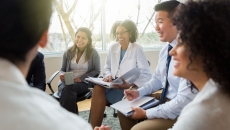 Five business people sitting on chairs in a circle