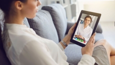 A woman talking to a provider on a tablet
