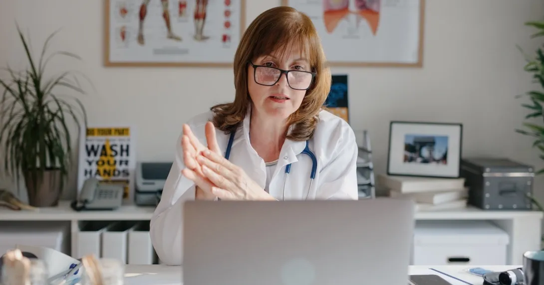 Healthcare professional reviewing data on a laptop