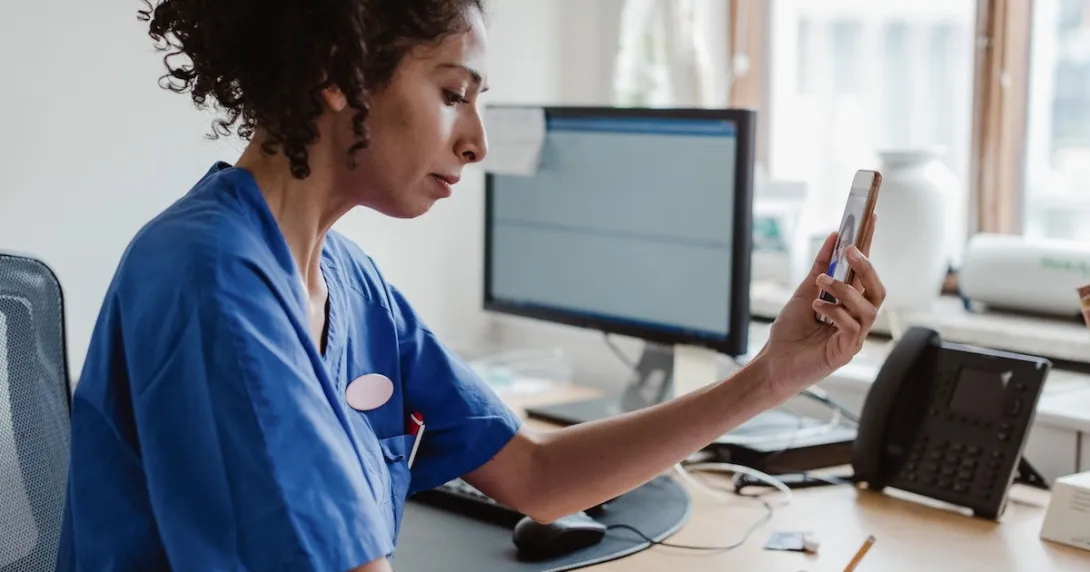 Healthcare professionals interacting with a person on a cell phone