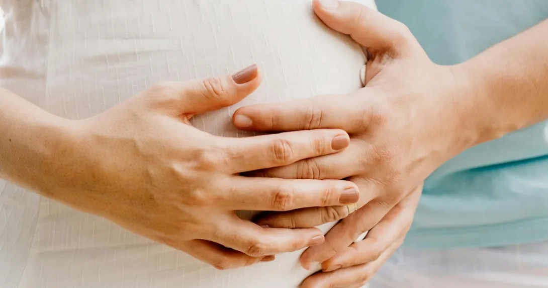Hands touching a baby bump