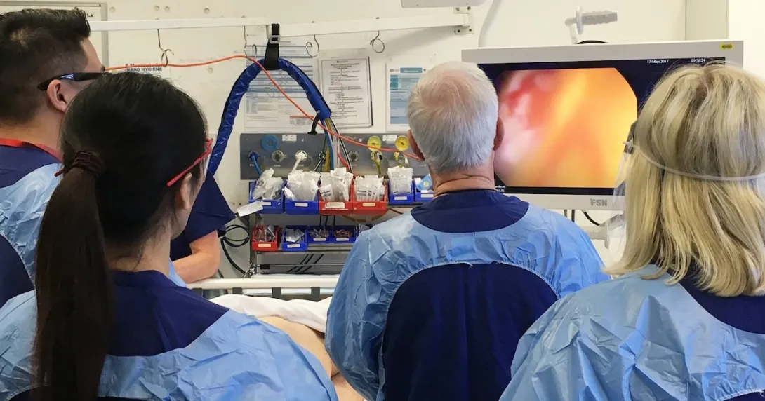 Surgeons performing a colonoscopy as part of a bowel screening