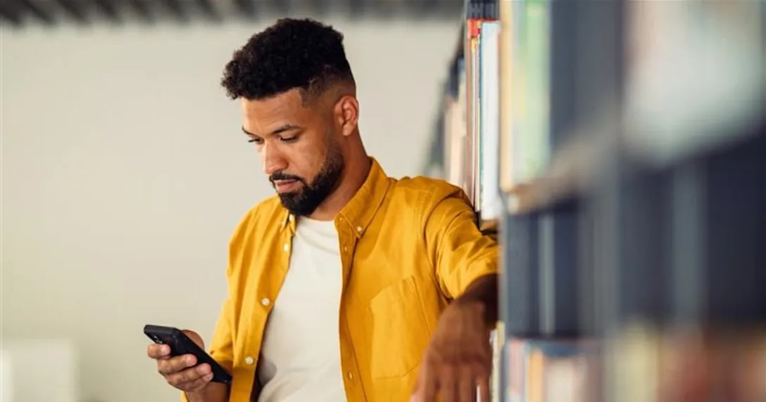 Person standing up and looking at a phone