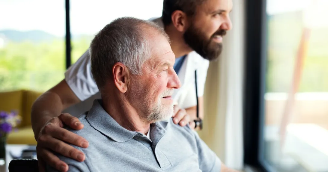 Patient in a chair with a healthcare provider standing next to them