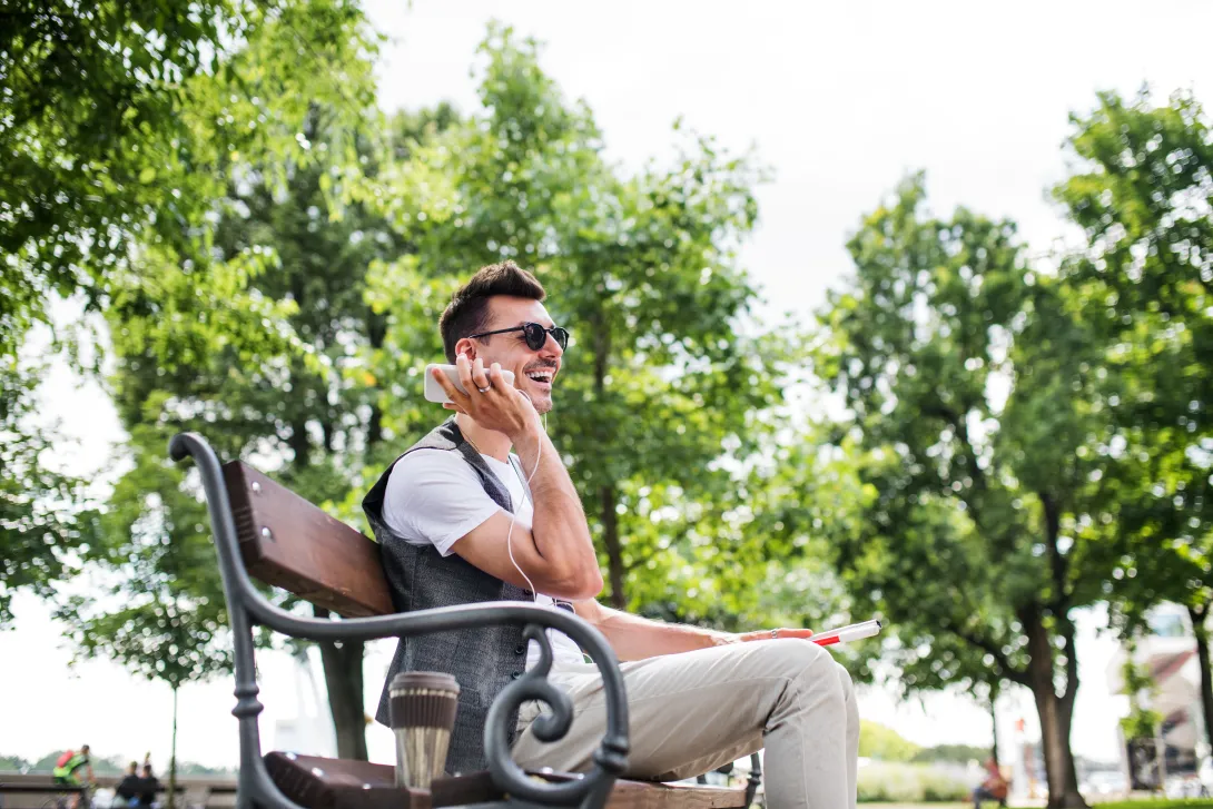 Blind person sitting on a bench in a park