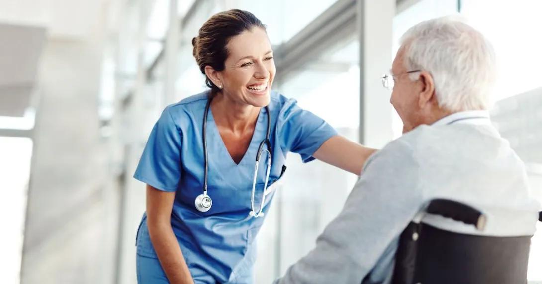 Healthcare provider standing next to a patient in a wheelchair