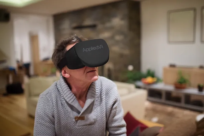 A man using an AppliedVR headset at home.