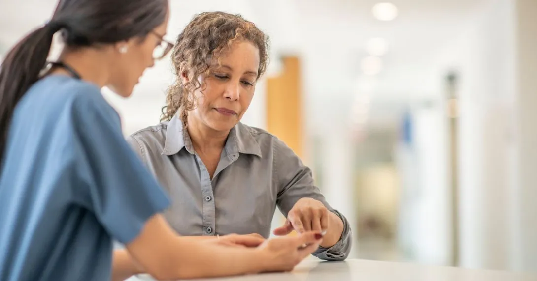 Healthcare provider standing up and talking to a patient who is also standing