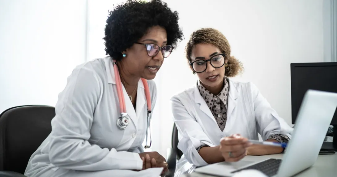 Two people sitting down and looking at a computer