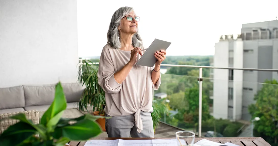 Person holding a tablet while standing on a balcony