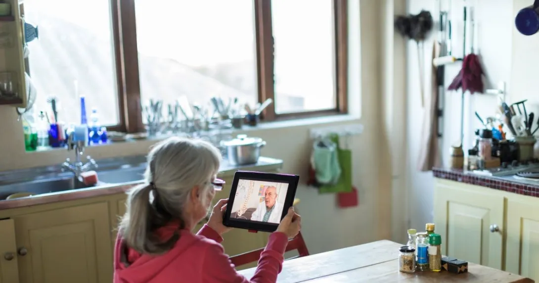 person holding tablet sitting at table