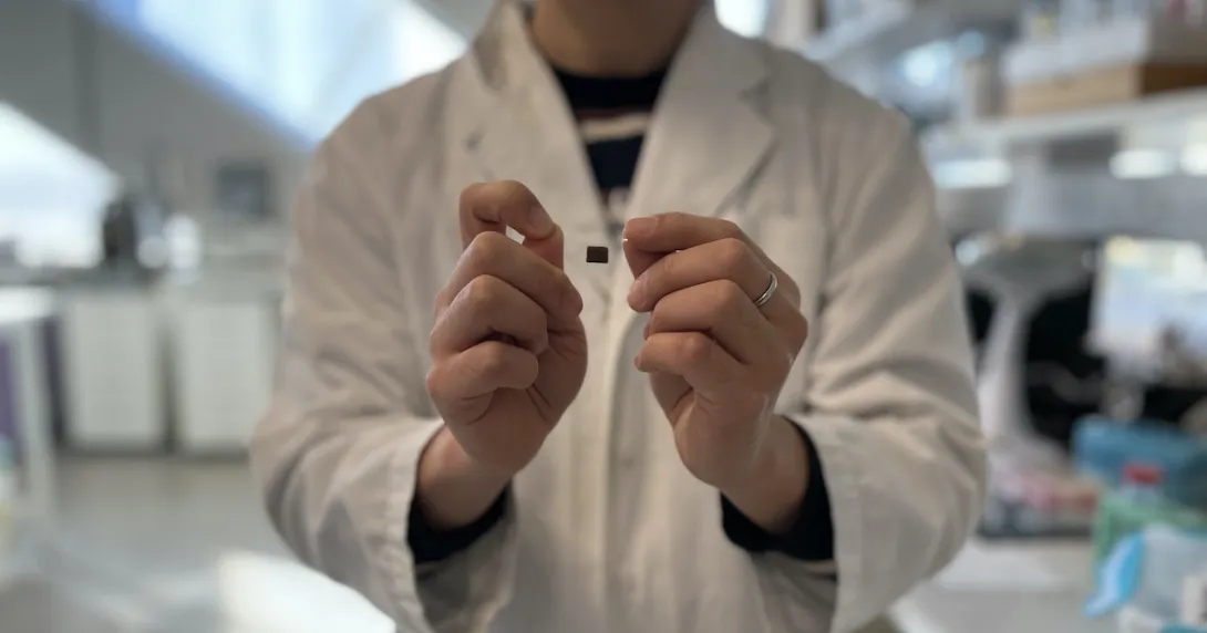 A researcher showing a wearable skin patch for remote health monitoring