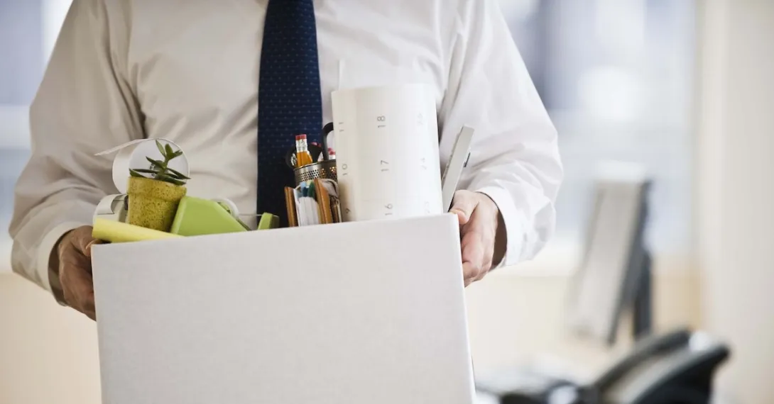 A worker holding a box of belongings.