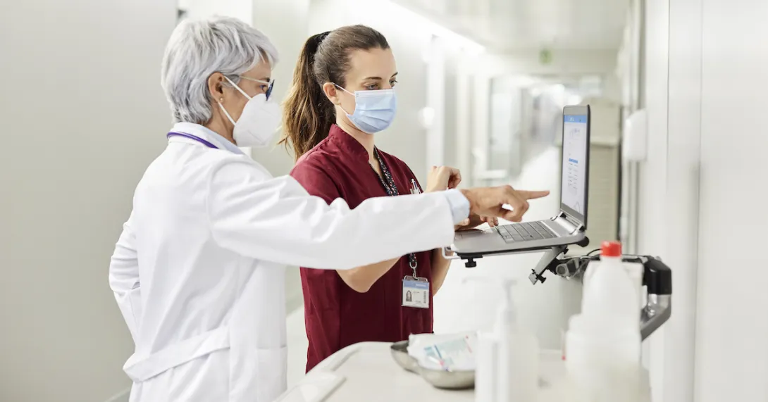 A doctor and a nurse using a computer together in a hospital.