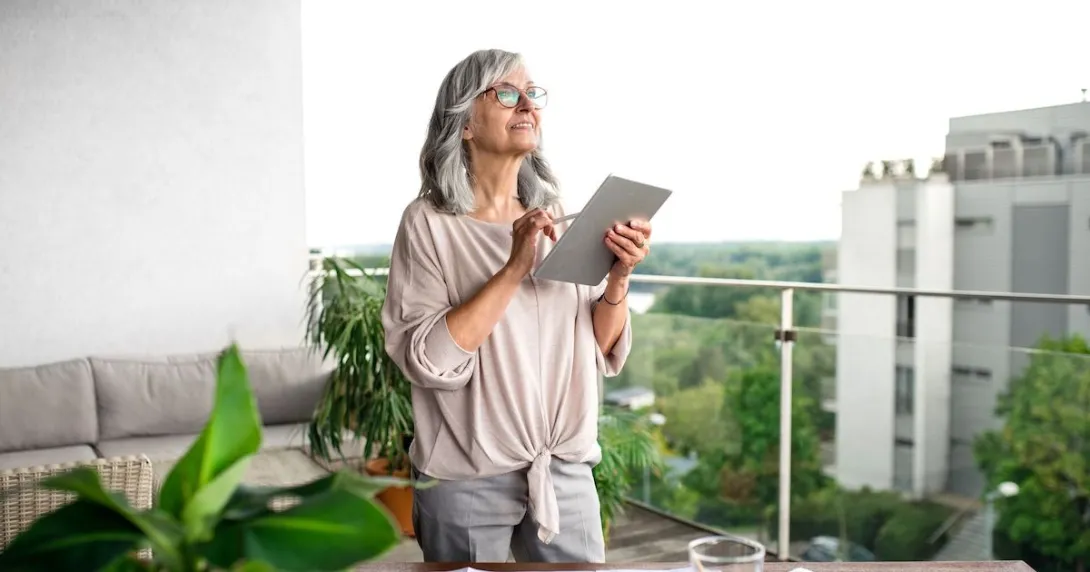 A woman standing at her desk using a tablet