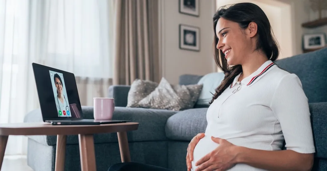 A pregnant person talking to a provider through a video chat on her laptop.