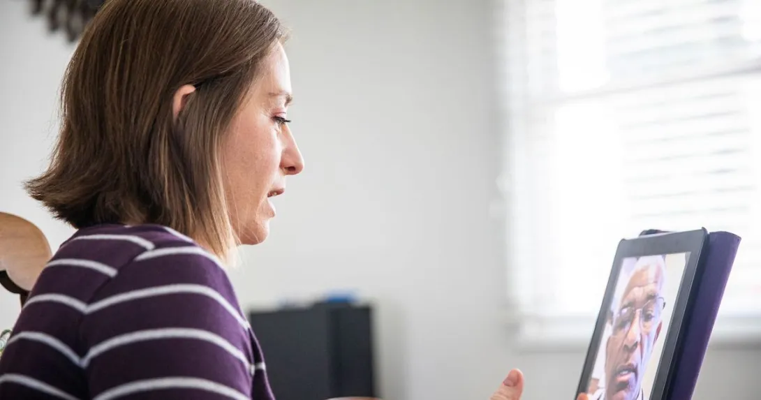 A woman talking to a provider on a tablet.