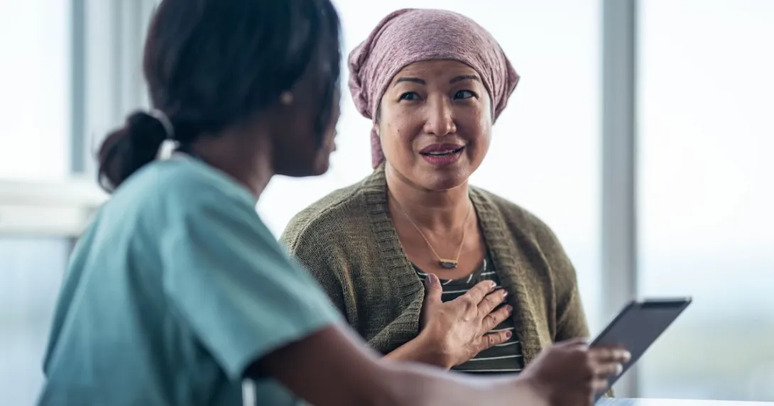 Healthcare provider talking to a patient while showing them a tablet