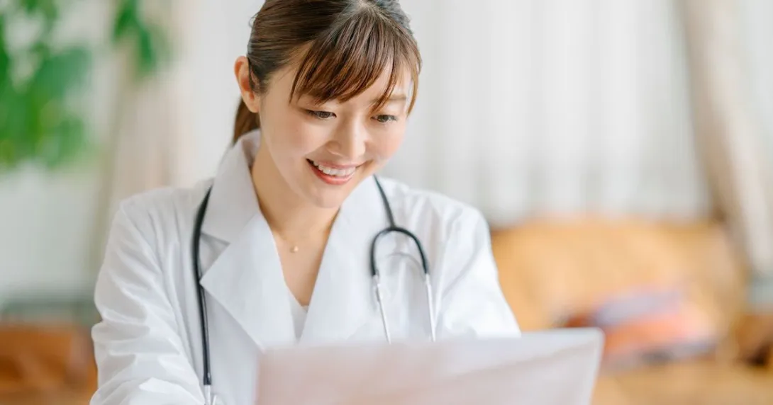 Healthcare provider sitting at a desk looking at a computer