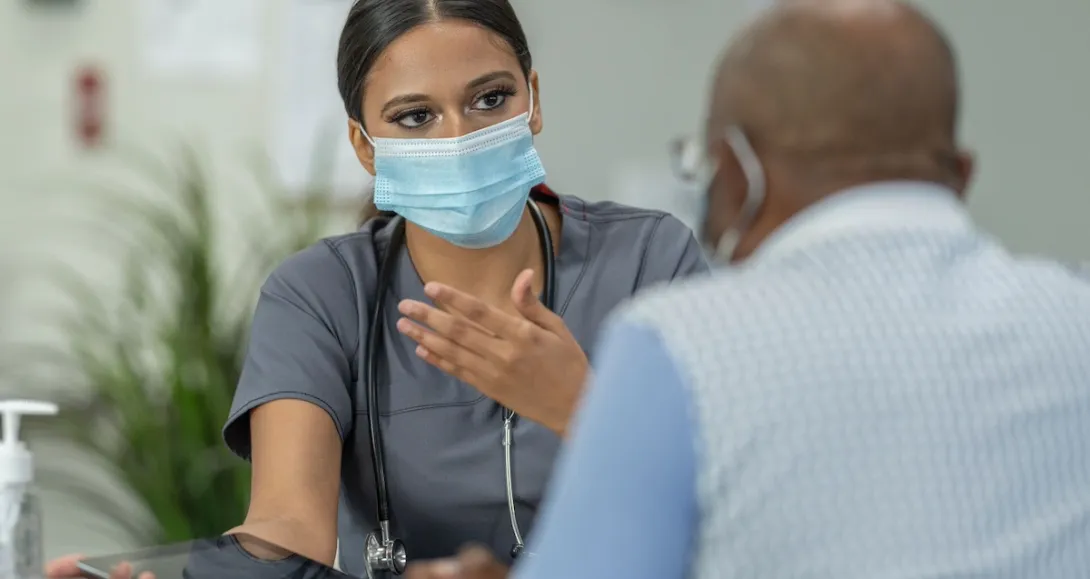Healthcare provider sitting and talking to a patient