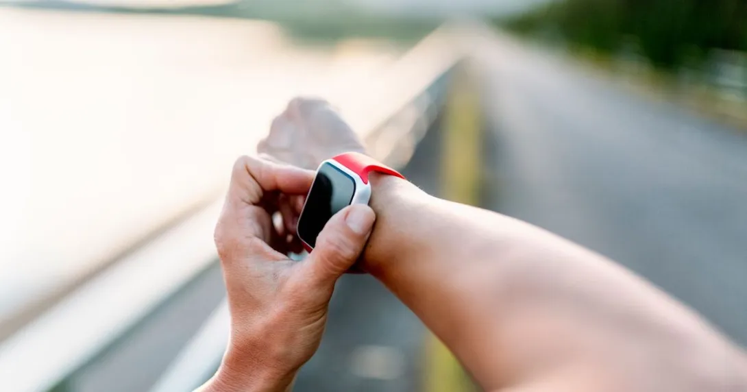 Person's arms with one hand playing with an Apple Watch
