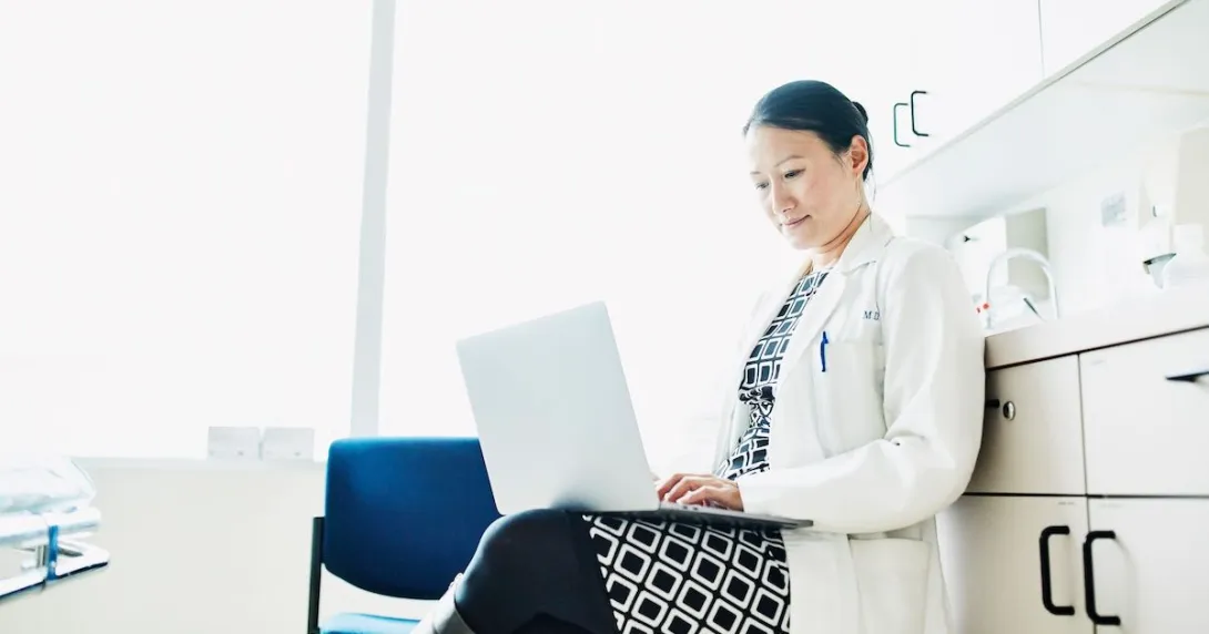 A doctor working on their laptop