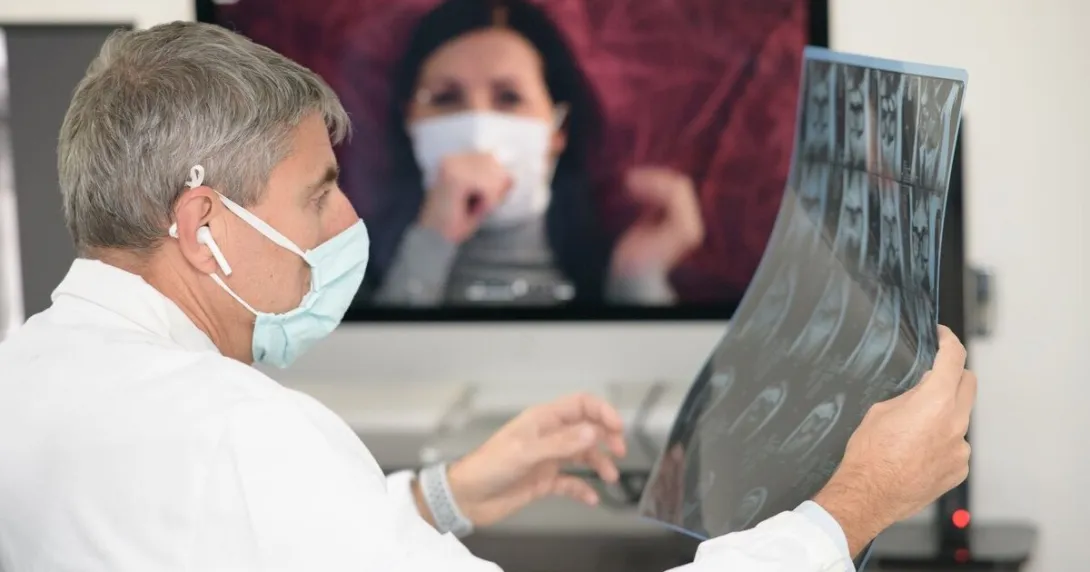 A doctor looking at a patient's x-ray while in a video consultation