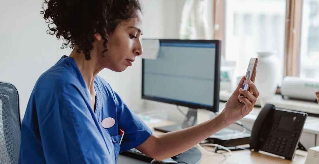 A doctor talking with a patient on a video call on her smartphone.