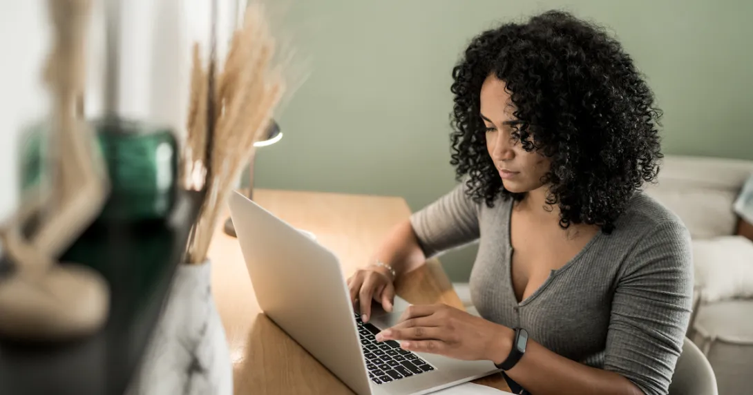 A person sitting at a desk using a laptop.